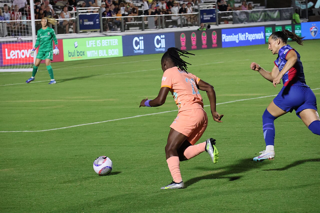 Barbra Banda advancing with the ball as Kaleigh Kurtz pursues her during Orlando Pride's match in Cary, North Carolina, June 15, 2024.